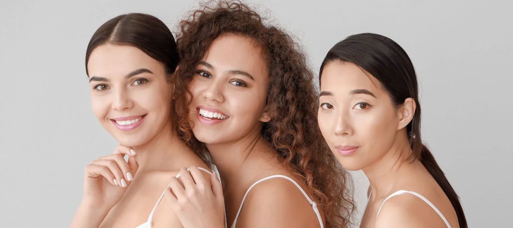 Three women with clear skin smiling