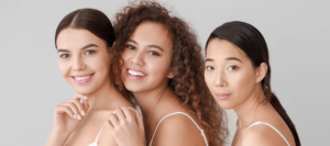 Three women with clear skin smiling
